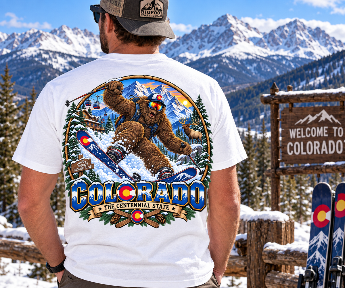 Colorado Bigfoot skiing shirt with Rocky Mountains, gondolas, elk, snow-covered pine trees and Centennial State design