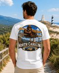 North Carolina Bigfoot shirt featuring Sasquatch flying a vintage biplane above Outer Banks and Blue Ridge scenery