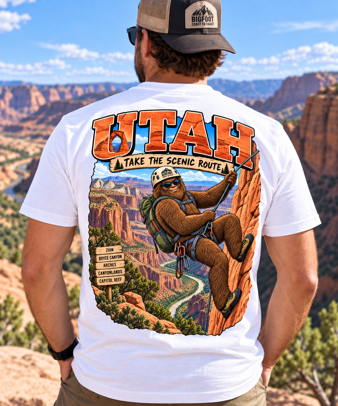 Utah Bigfoot Take the Scenic Route shirt featuring Sasquatch rappelling through a colorful red rock canyon landscape.